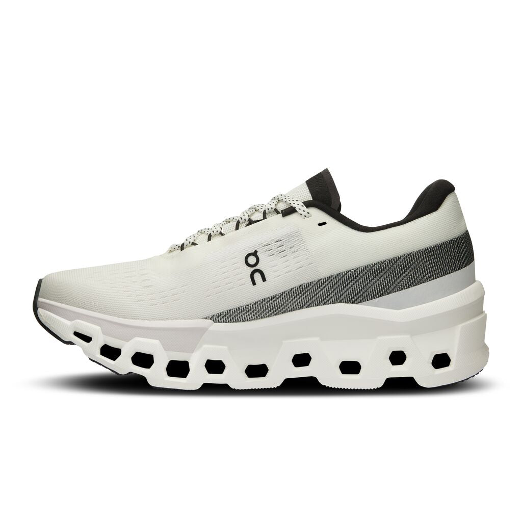 The medial side of the On Cloudmonster 2 has a small On logo in the middle of the shoe and a black and white stripe around the heel through the middle of the foot