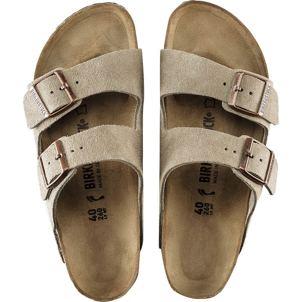 Pair of beige sandals with double straps on a white background