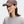 Woman wearing a grape colored cap and gray shirt with a logo on a white background