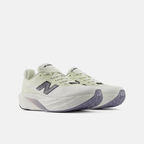 A pair of New Balance running shoes in a light cream and off-white colorway with dark gray 'N' logos and purple accents on the midsole and outsole, shown against a light gray background.