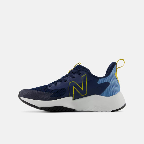 A New Balance athletic sneaker in navy blue with a light blue mesh heel, a prominent yellow outlined 'N' logo, and a thick white midsole, shown from a side profile on a light gray background.