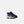A toddler's New Balance sneaker in navy blue, light blue, and yellow, shown from a side profile on a light gray background.