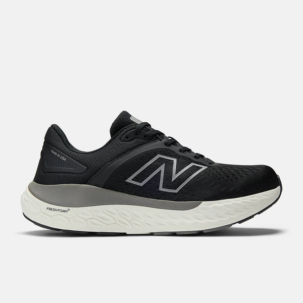 Black running shoe with white sole on a light gray background