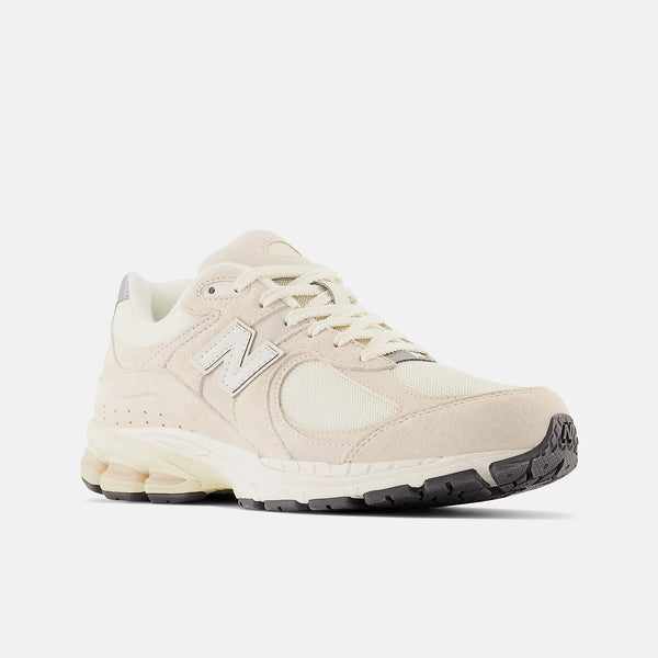 Beige sneaker with New Balance logo on a white background