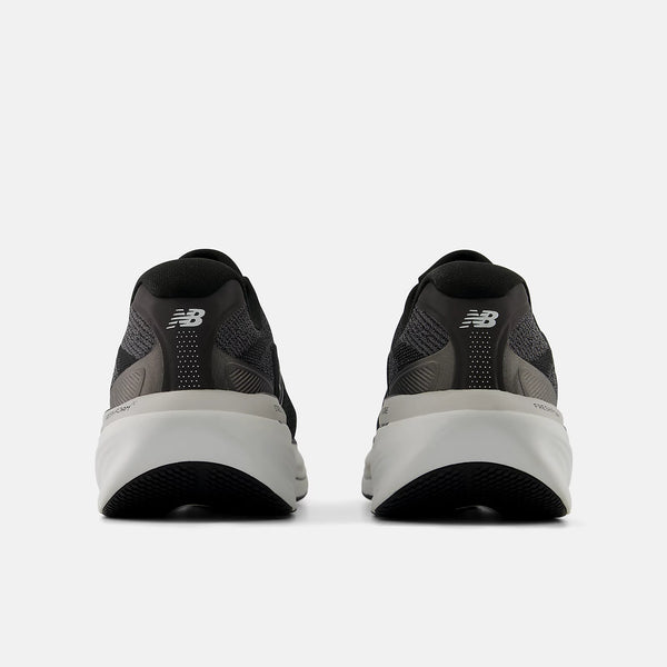 Black running shoes with white soles on a white background