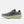 Gray running shoe with a green sole on a white background