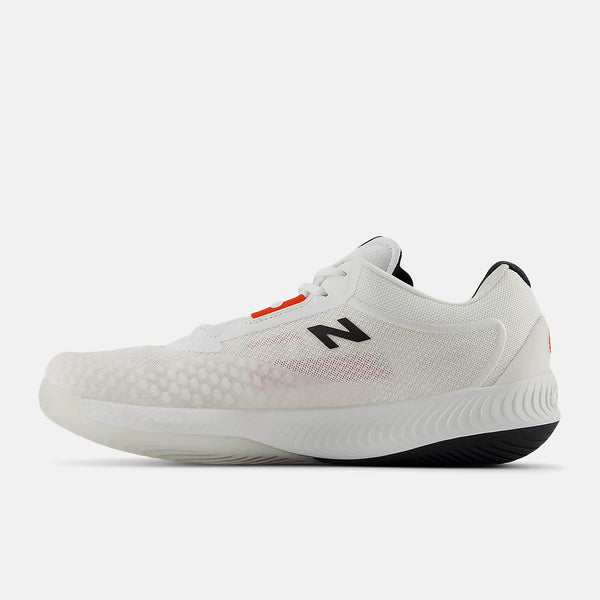 A white New Balance athletic shoe with a textured knit upper, a black 'N' logo on the side, a small orange accent near the laces, and a black outsole, shown against a light gray background.