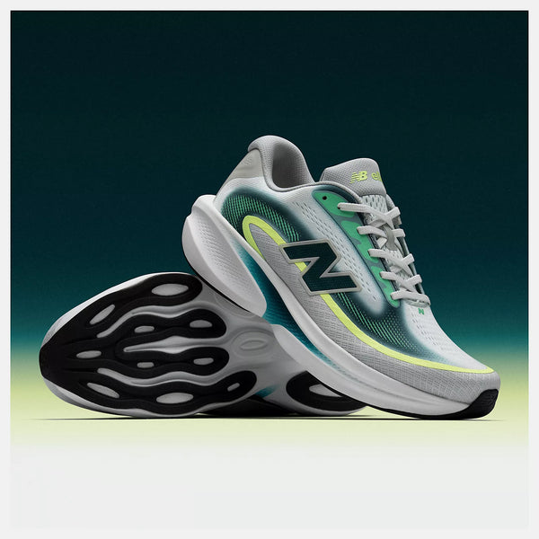 White and green running shoe with black sole on a gradient background