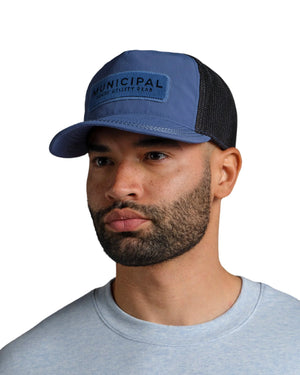 Man wearing a blue cap with 'Municipal Utility Gear' logo on a white background.