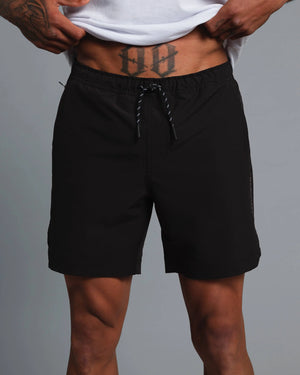 Person wearing black shorts on a gray background
