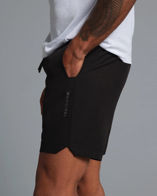 Person wearing black shorts with 'Municipal' branding on a gray background