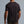 Man wearing a black t-shirt against a gray background