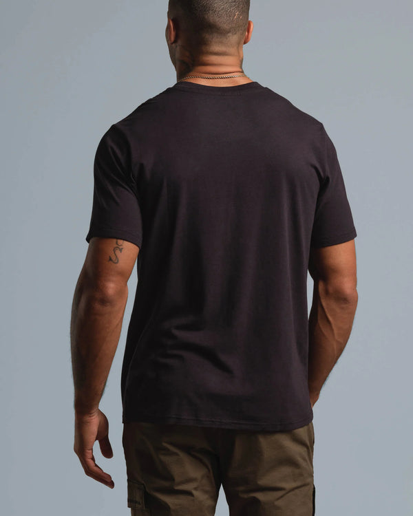 Man wearing a black t-shirt against a gray background