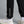 Black pants with 'MUNICIPAL' text worn by a person on a gray background