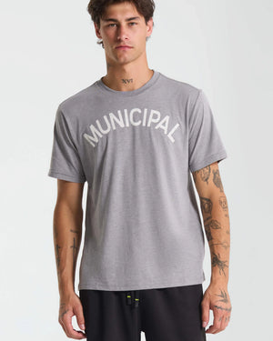 Person wearing a gray t-shirt with 'MUNICIPAL' text on a plain background.