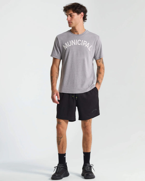 Man wearing a gray 'Municipal' t-shirt and black shorts on a white background