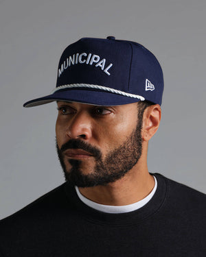 Man wearing a navy blue cap with 'MUNICIPAL' text on a gray background.