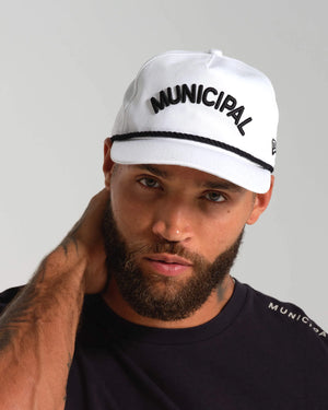 Man wearing a white cap with 'MUNICIPAL' text on a gray background