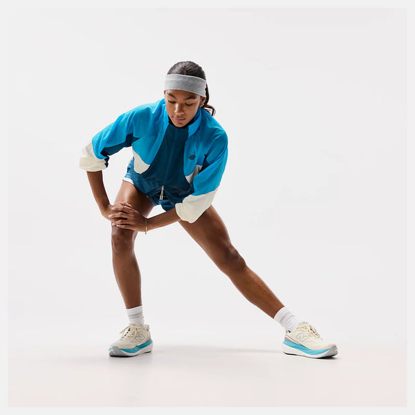Person wearing a blue tracksuit with white accents on a white background