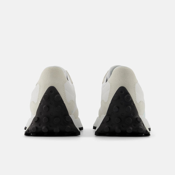 Pair of white sneakers with black soles on a light gray background