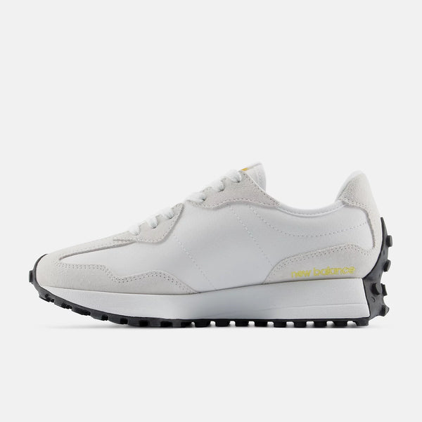 White sneaker with yellow accent and yellow New balance logo on a white background.