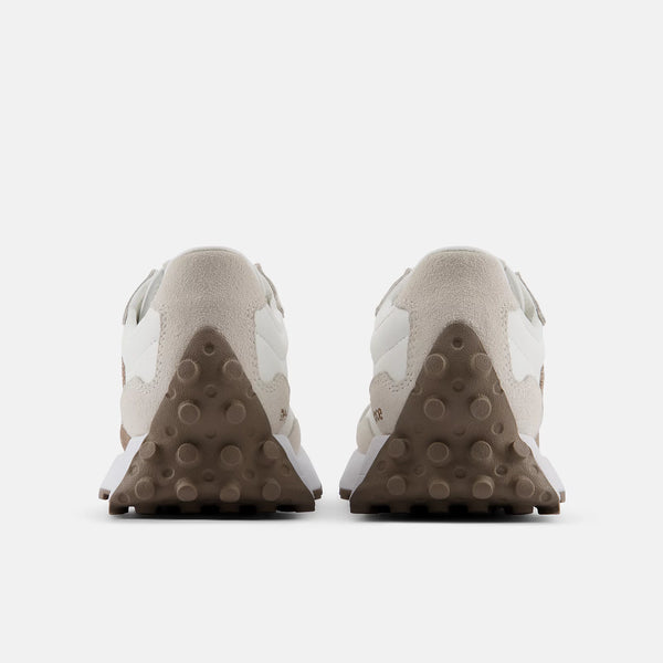 Pair of beige sneakers with brown soles on a white background