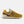 A pair of New Balance 574 sneakers in a mustard yellow and beige colorway,  on a light gray background.