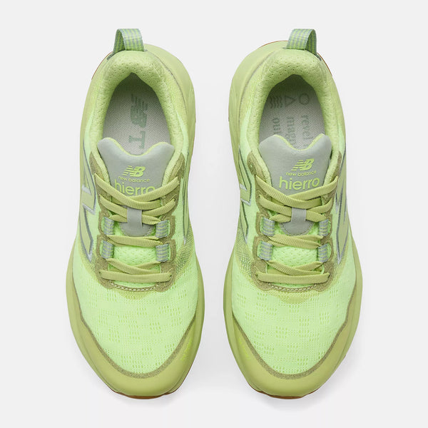 Pair of light green new balance trail running shoes on a white background