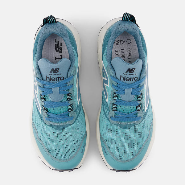 A pair of New Balance trail shoes that have a tab on the back from a top down view.