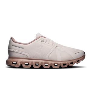 A single running shoe shown in a side profile on a clean white background. The shoe features a light off-white mesh upper with subtle tonal detailing, a pale pink collar lining, and a muted dusty rose midsole and outsole.