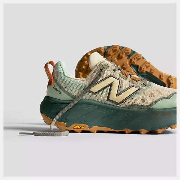 Green and brown sneaker with New Balance logo on a light gray background
