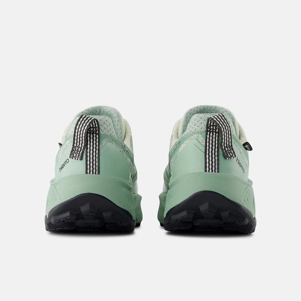 Green hiking shoes with black soles on a white background