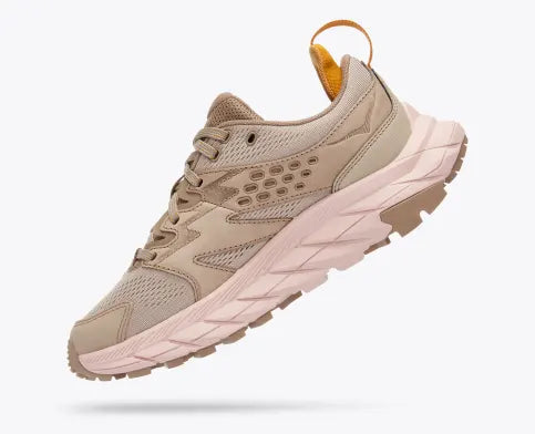 Medial angled view of the Women's HOKA Anacapa Breeze Low trail shoe in the color Oxford Tan / Peach Whip