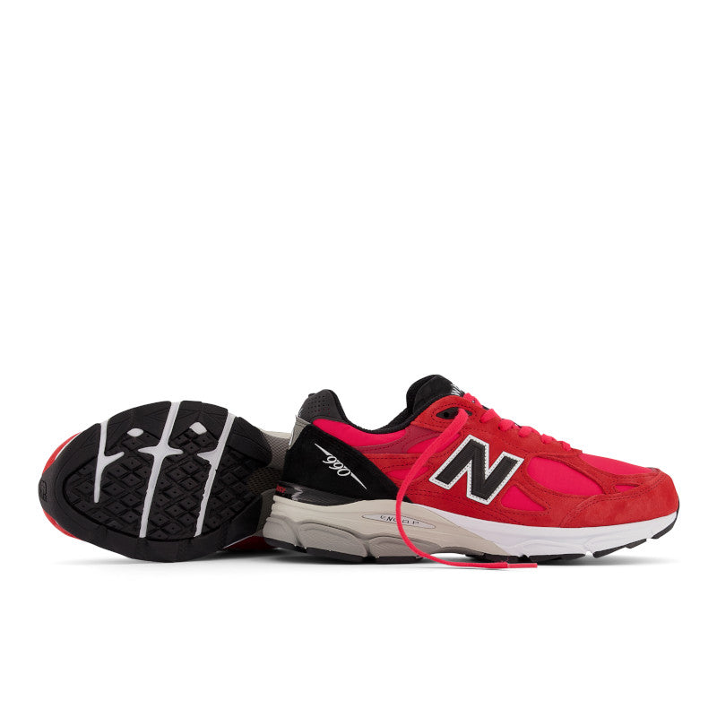 A pair of Men's 990 V3 shoes by New Balance.  One showing a lateral view and the other showing the bottom (outer sole) view.
